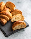 Cut in half croissant with inside texture and thin crisp layers on stone board, grey background. Delicious french pastry