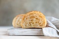 Cut in half croissant with inside texture and thin crisp layers on wooden board, light concrete background. Delicious french