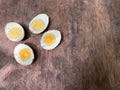 Cut in half of two hard-boiled eggs on natural brown wood table Royalty Free Stock Photo
