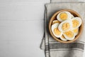 Cut hard boiled chicken eggs in bowl on wooden table, flat lay. Space for text Royalty Free Stock Photo