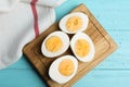 Cut hard boiled chicken eggs on blue wooden table, flat lay Royalty Free Stock Photo