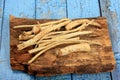 Cut Horseradish roots Armoracia rusticana taproot on rustic wooden board Royalty Free Stock Photo