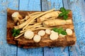 Cut Horseradish roots Armoracia rusticana taproot on rustic wooden board Royalty Free Stock Photo