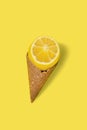 Cut Lemon with ice cream cone on bright illuminating yellow background