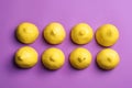 Cut lemons symbolizing women`s breasts and one with nipple piercing on purple background, flat lay