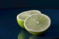 Cut lime fruit on a dark teal plate Royalty Free Stock Photo