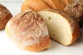 Cut loaf of freshly baked bread on white table, closeup Royalty Free Stock Photo