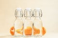 Cut off mandarins through water bottles on a beige background Royalty Free Stock Photo