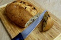 A cut olive loaf on a board with bread knife Royalty Free Stock Photo