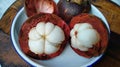 Cut open too ripe mangosteens against rustic white background