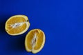 Cut orange on blue background, minimalist photography