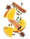 Cut orange and different spices falling on white background. Mulled wine ingredients Royalty Free Stock Photo