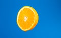 Cut orange. Orange juice drips. Half the fruit. Fresh citruses. Oranges on a blue background. Juicy fruit. Naral vitamins.