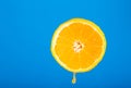 Cut orange. Orange juice drips. Half the fruit. Fresh citruses. Oranges on a blue background. Juicy fruit. Naral vitamins.