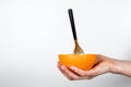 Cut orange with a spoon in a woman `s hand. Vitamins, health and vegans Royalty Free Stock Photo