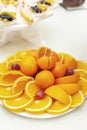 Cut orange and tangerine fruit on white plate