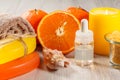 Cut orange with two whole oranges, towel, soap, sea shell, bottle with aromatherapy oil, glass bowl with yellow sea salt and burn Royalty Free Stock Photo