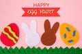 Cut out of felt applications of eggs and white and brown rabbits on the grass. Pink background. Flat lay. Easter holiday Royalty Free Stock Photo