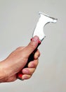 Cut-out image of a hand holding a steel all-in-one painters tool isolated on white background. Royalty Free Stock Photo