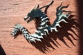 cut-out paper dragon with shadow dancing on a brick wall Royalty Free Stock Photo