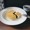 Cut out a quarter of moon cake served with tea in a round white plate on wooden background. Royalty Free Stock Photo