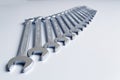 Cut-out wrenches horizontally placed from the biggest to the smallest in a row. Top view composition. Hand tool. Tools