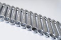 Cut-out wrenches horizontally placed from the biggest to the smallest in a row. Top view composition. Hand tool. Tools