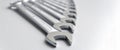 Cut-out wrenches horizontally placed from the biggest to the smallest in a row. Top view composition. Hand tool. Tools