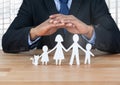 Cut outs of family under protective hands