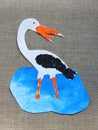 Cut and painted colorful stork bird on linen background