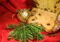 Cut panettone, branch of fir tree, golden bauble. Christmas theme.