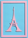 Cut from the paper Eiffel Tower on a turquoise textured background