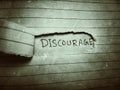 cut paper the word discouraged appeared on the next page written by pencil Royalty Free Stock Photo