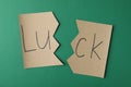 Cut paper with word LUCK on green background