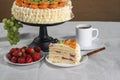 Cut piece of cake made from natural ingredients, fresh kiwi fruit, grapes, tangerine and strawberries stands on a table Royalty Free Stock Photo