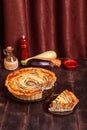 The cut piece of Vegetable Spiral tart with zucchini, eggplant, carrot on wooden background