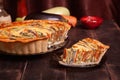 The cut piece of Vegetable Spiral tart with zucchini, eggplant, carrot on wooden background