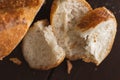 Cut into pieces fresh loaf of wheat porous bread. Slices of french baguette. Close-up photo Royalty Free Stock Photo