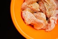 Cut pieces of uncooked chicken, seasoned with turmeric paste, inside plastic bowl