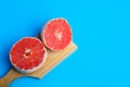 Cut pink grapefruit isolated on blue background. Royalty Free Stock Photo