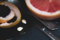 A cut pink grapefruit with a knife and a spoon on a dark surface Royalty Free Stock Photo