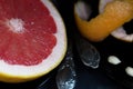 A cut pink grapefruit with a knife and a spoon on a dark surface Royalty Free Stock Photo