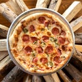 Cut pizza with salami, olives and melted cheese on round dish on firewood background. Authentic cooking on an open fire Royalty Free Stock Photo