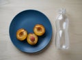 Cut Plums On Blue Plate Next To Plastic Bottle Royalty Free Stock Photo