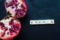 Cut pomegranate on a black background. Anemia concept