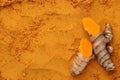 Cut raw root on aromatic turmeric powder, top view. Space for text Royalty Free Stock Photo