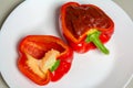 Cut the red pepper into two parts, one half stuffed with sauce. Royalty Free Stock Photo