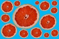 cut round bright red orange half grapefruit slices on colorful light blue backdrop Royalty Free Stock Photo