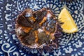 Cut sea urchins laid in the shell on a dish with lemon