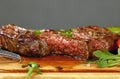 Cut slices of grilled beefsteak on board close up